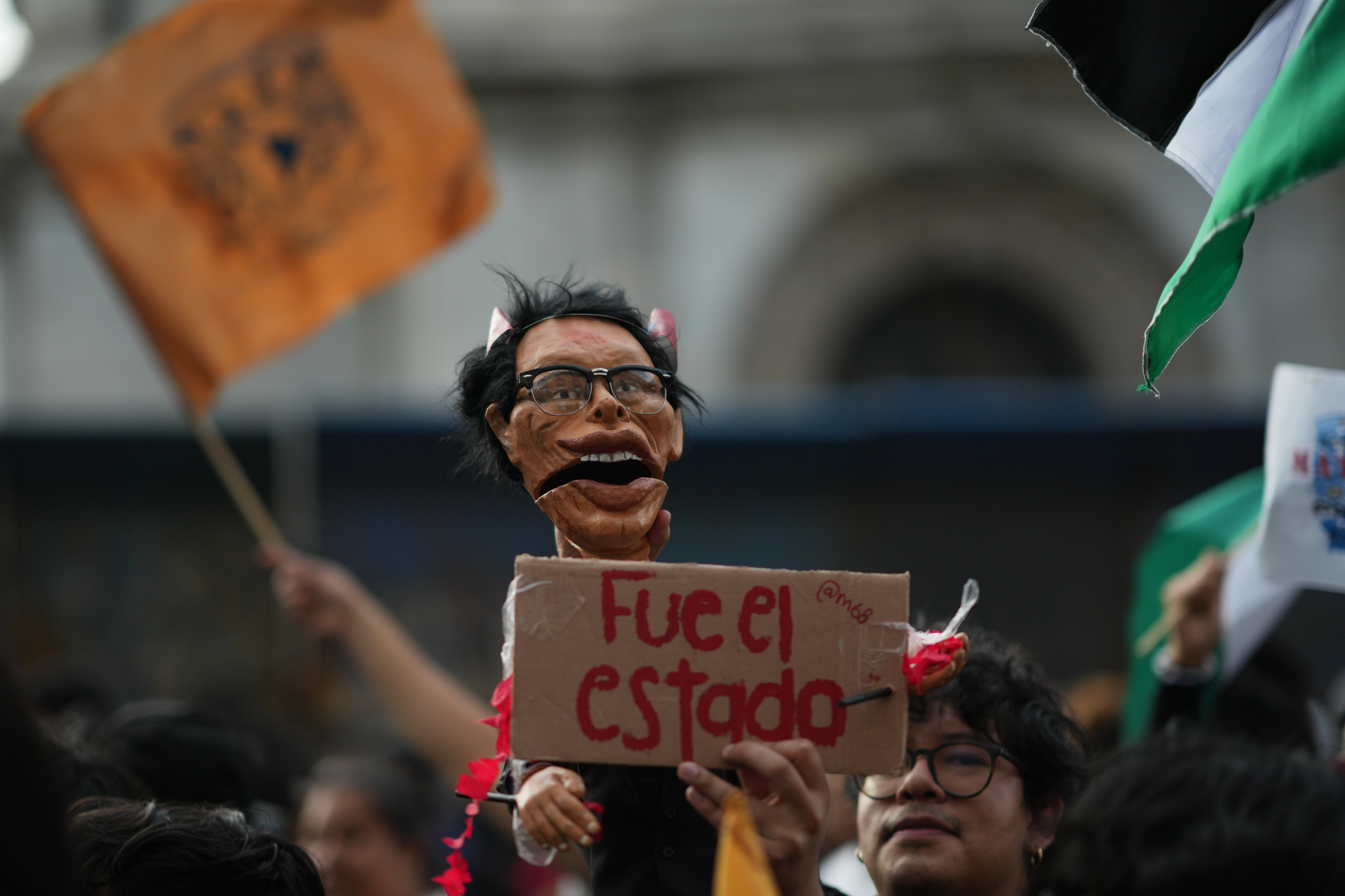 A protester holds a doll representing former President Gustavo Diaz Ordaz during a protest commemorating the anniversary of the 1968 Tlatelolco killings, when soldiers fired on student protesters, in Mexico (AP)